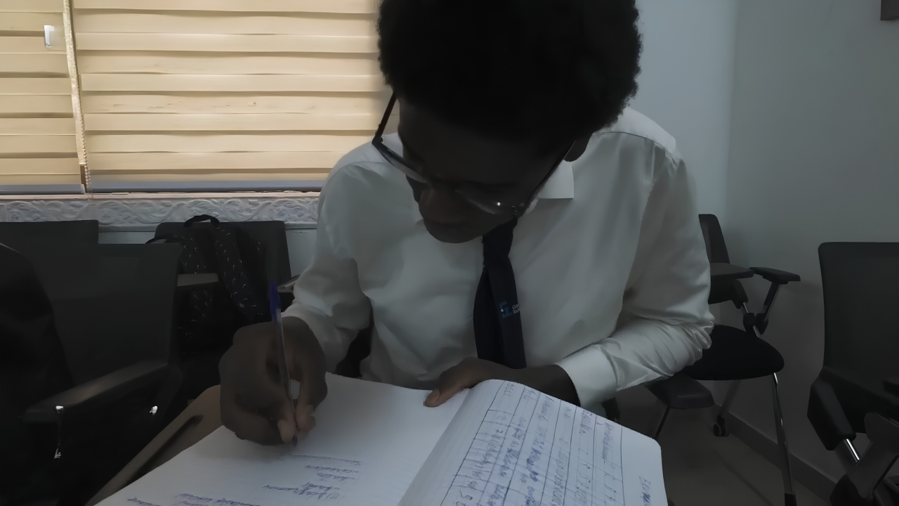 Étudiant GDS en costume et cravate concentré sur ses notes