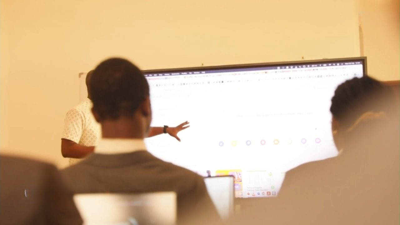 Formateur pointant un écran de cours devant des étudiants GDS
